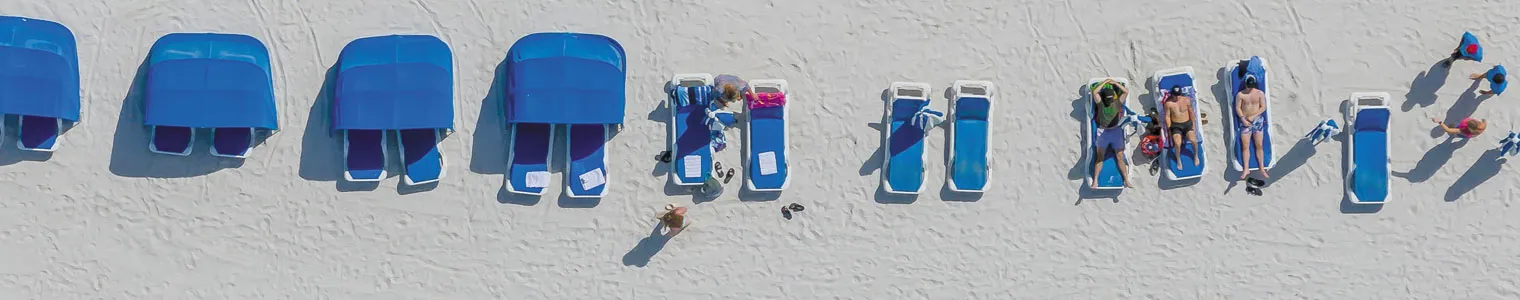 drone view over beautifu beach with lively crowds with sunbeds and umbrelas