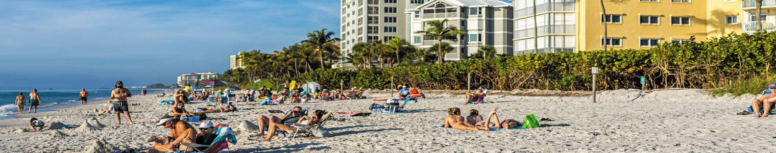 vanderbilt beach in naples city with people sitting and relaxing on sand