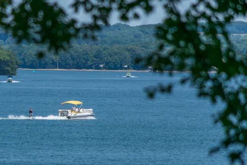 water skiing on the lake during summer vacation with a pontoon boat